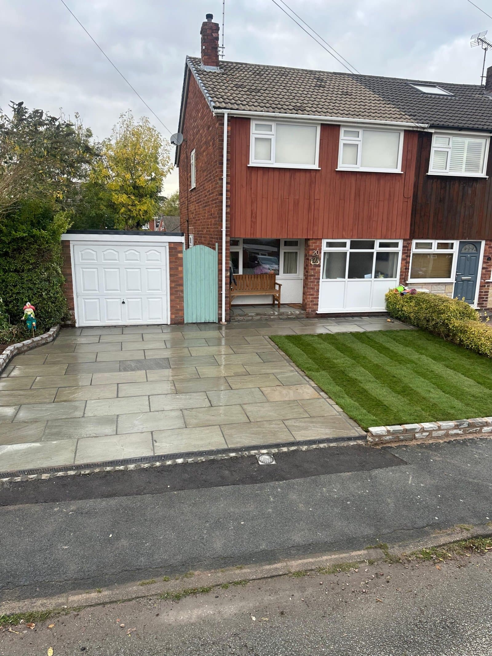 Indian sandstone driveway and striped front lawn at a Cheshire home