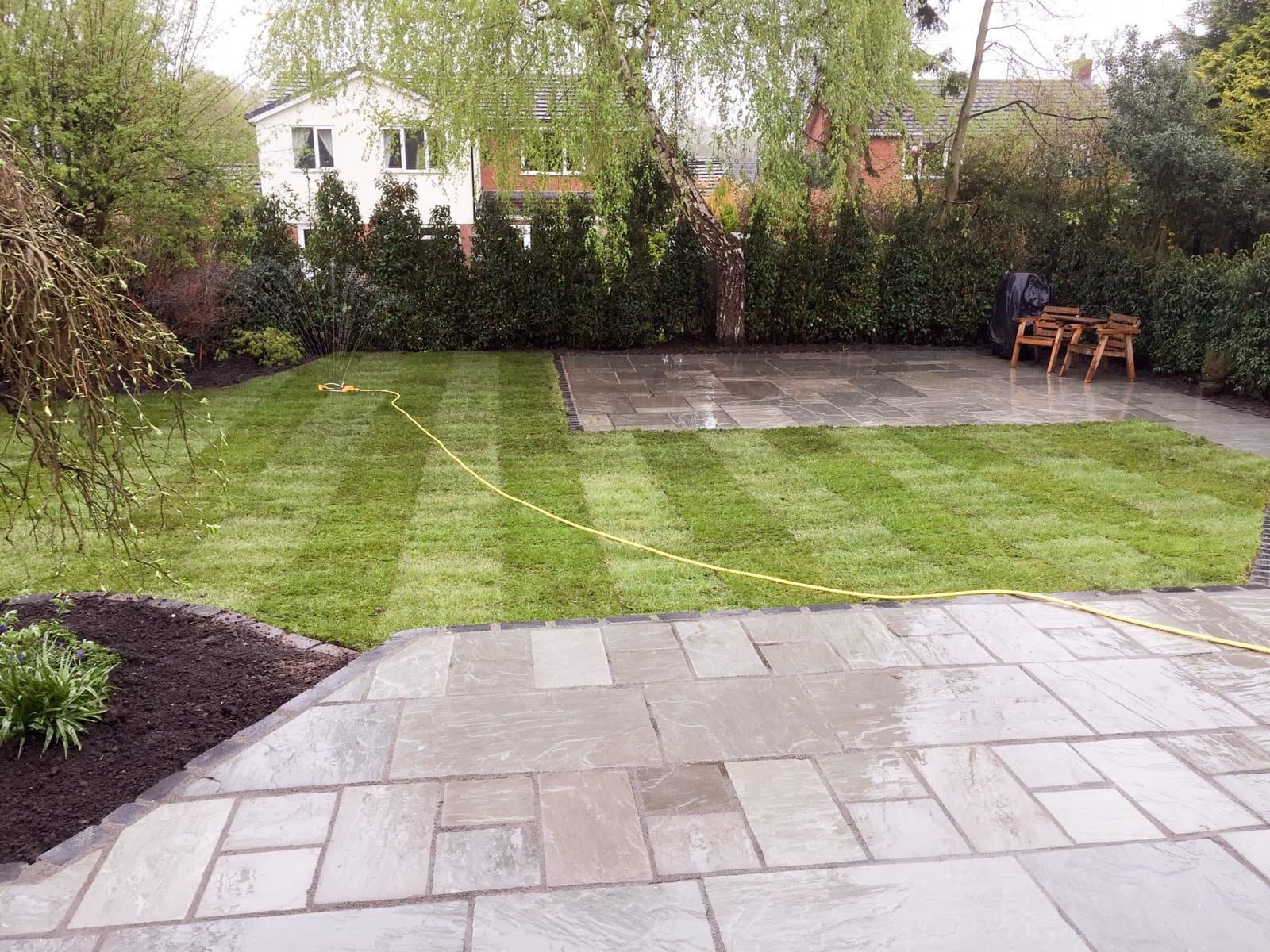 Striped new lawn meeting a sandstone patio in a completed Cheshire garden