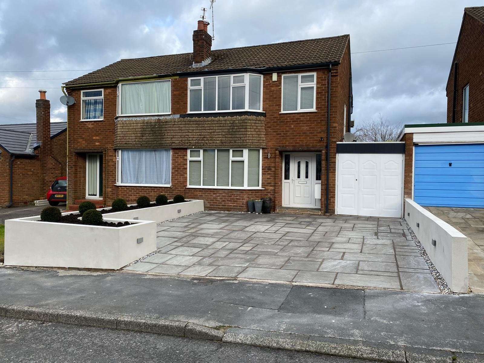 Grey porcelain driveway with white rendered planters at a Cheshire semi