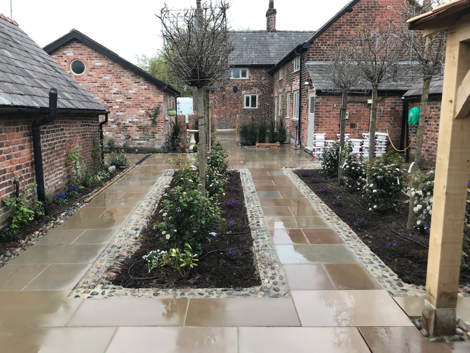 Sandstone pathways with cobble-edged planting beds in a period Cheshire farmhouse courtyard