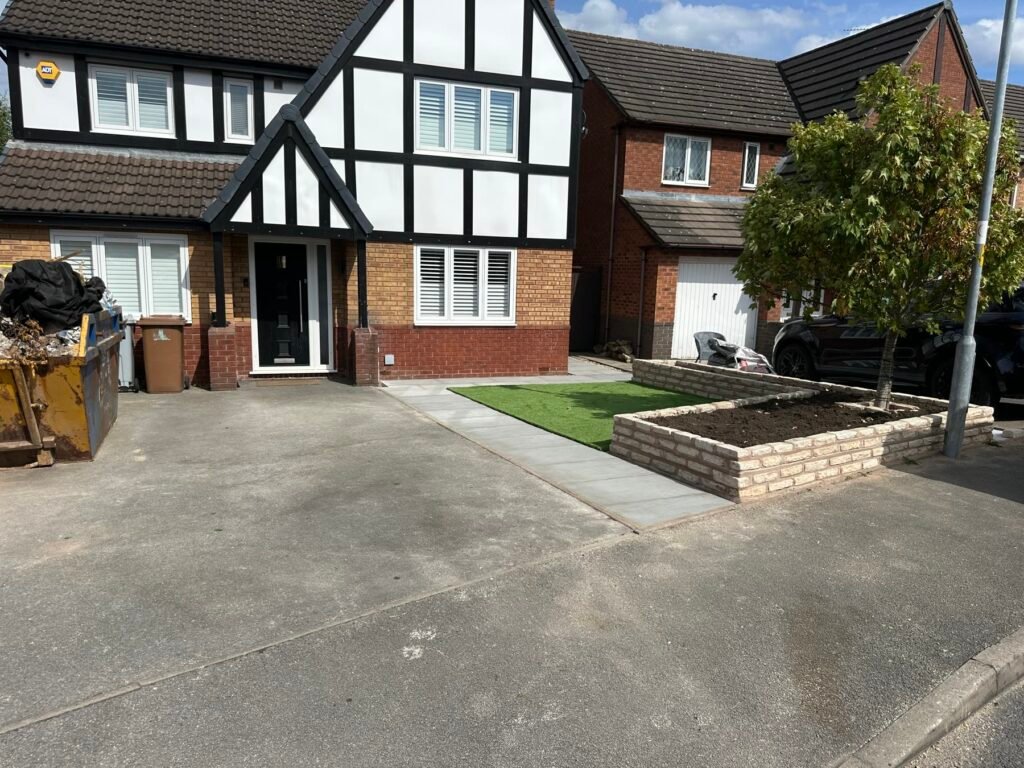 Sandstone path, artificial lawn and raised planter around the existing tree, White Park Close, Middlewich